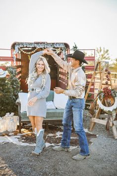 a man standing next to a woman in front of a truck with christmas decorations on it