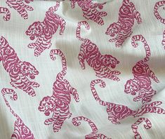 a white and pink fabric with red tiger designs on the front, in full view