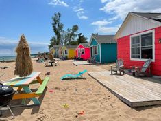 colorful beach huts and picnic tables on the sand