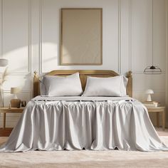 a bed with white sheets and pillows on top of it in a room next to a table