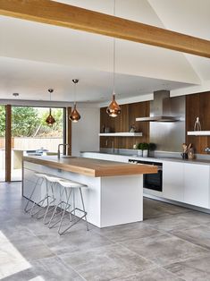 a modern kitchen with an island and bar stools