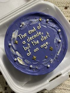 a blue plate with writing on it sitting in a plastic container that says the end of a decade, but the start of an age