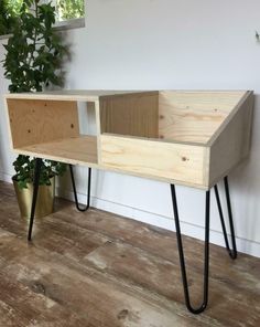 a wooden shelf with hairpin legs and a plant