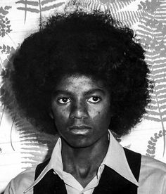 a black and white photo of a person with an afro