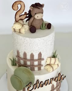 a birthday cake with a horse on top and the number two is decorated in fondant