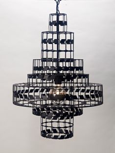 a chandelier made out of black and white squares hanging from a ceiling fixture