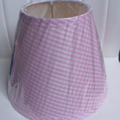 a pink and white checkered lamp shade on a table