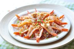 a white plate topped with shrimp and veggies on top of a green table cloth