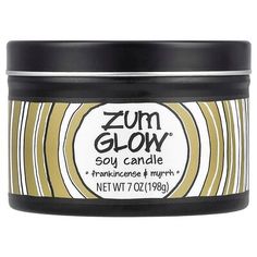 a jar of zum glow soy candle in yellow and white with black lid on a white background