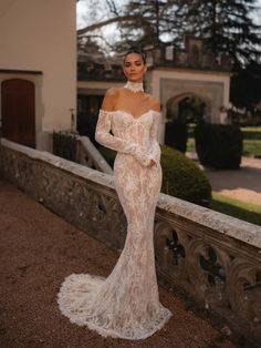 a woman in a wedding dress standing on a balcony with her hands on her hips