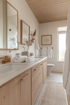 a bathroom with wooden cabinets and white towels