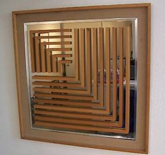 a mirror that is on the wall in front of a wooden paneled window frame