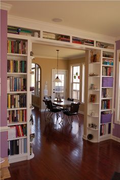 an open living room and dining area with bookshelves