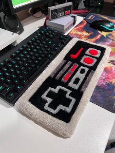 a computer keyboard sitting on top of a white desk next to a mouse and monitor