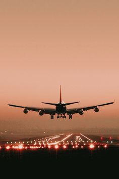 an airplane is taking off from the runway at sunset or dawn with its landing gear down