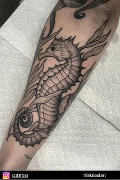 a black and white photo of a seahorse tattoo on the arm with an octopus