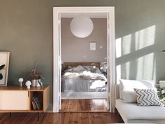 a living room filled with furniture next to a white couch and table on top of a hard wood floor