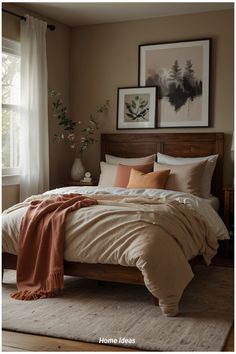 a bedroom with a large bed and two pictures on the wall above it, along with an orange throw blanket