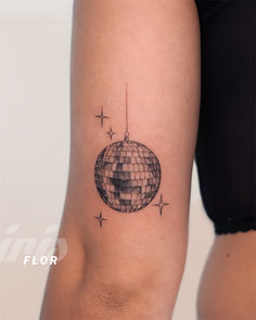 a woman's arm with a disco ball tattoo on the left side of her body