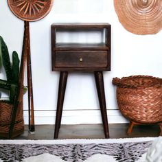 a wooden table sitting on top of a rug next to a wall with baskets and plants