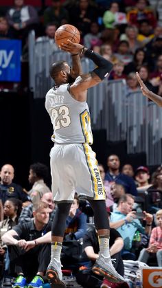 the basketball player is trying to dunk the ball in front of an audience at a game