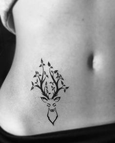 a black and white photo of a woman's stomach with a deer tattoo on it