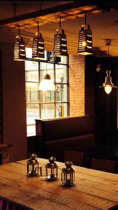 a wooden table with four lights hanging from it