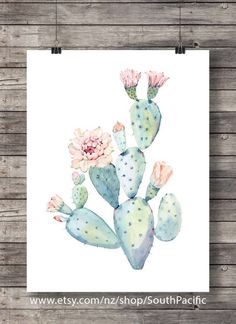 a watercolor painting of a cactus with pink flowers on white paper next to wood planks