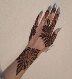 a woman's hand with henna tattoos on it