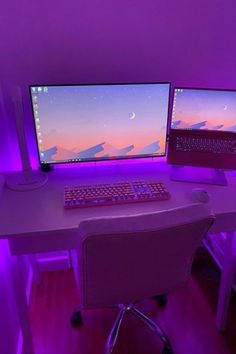 two computer monitors sitting next to each other on top of a desk in front of a purple light