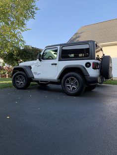 a white jeep parked in front of a house