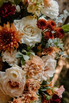 a bunch of flowers that are sitting on a table in front of a tree trunk