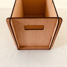 an empty wooden box sitting on top of a white surface