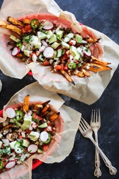 two bowls filled with food sitting on top of a blue table next to silverware