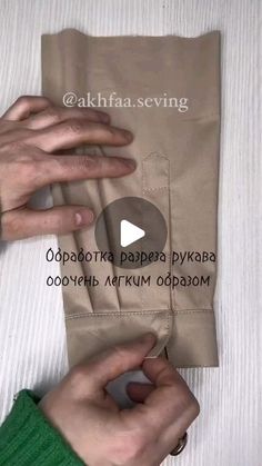 two hands are holding something in front of a bag that has been folded up and is being held by another hand