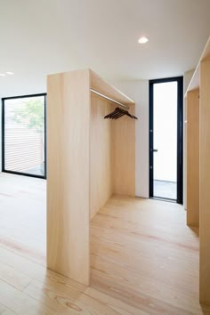 an empty room with wooden flooring and black glass doors leading to the back yard