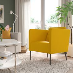 a yellow chair sitting in front of a window next to a white table with a potted plant on it