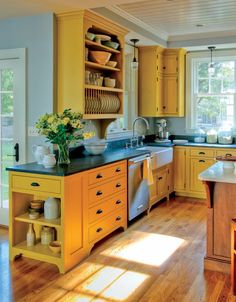 a large kitchen with yellow cabinets and wooden floors is pictured in this image from the inside