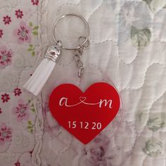 a red heart shaped keychain with a tassel hanging from it