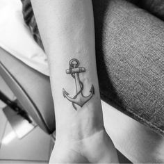 a small anchor tattoo on the left inner forearm and wrist is shown in black and white