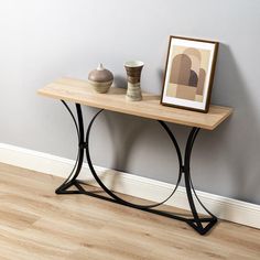 a wooden table with two vases on it and a framed photograph next to it