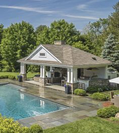 a pool house with a covered patio next to it and a swimming pool in the foreground