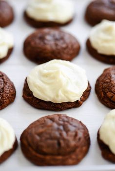 chocolate cookies with white frosting on a baking sheet