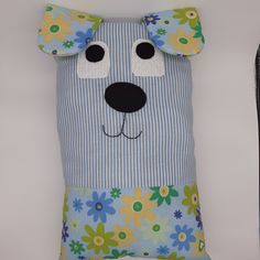 a blue and white pillow with a dog's face on it, sitting next to a snowboard