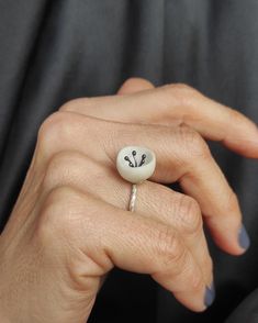 "This minimal distinctive ring is made of silver and matte white porcelain. The shape of the porcelain is round and hollow with irregular edges and the inside part is decorated with oxidized silver wires. The band has a very nice particular texture.A very simple ring for your everyday outfit. There may be a slight difference between the pieces, because they are all made by hand one by one. The porcelain is left matte, in its natural texture , without any use of enamel and glazing, highlighting its beauty and its properties. Handle with care because porcelain is somewhat brittle in such a small scale. If it falls down on a hard surface, it can be damaged. Each piece is hand shaped by me before being fired in a kiln to 1240C. DESCRIPTIONS and MEASUREMENTS: Materials:Sterling silver and oxidi Handmade White Enamel Ring, Elegant Handmade Silver Enamel Ring, Silver Clay Ring, Jewellery Ceramic, Ceramic Diamond Jewelry, Ring Ceramic Jewels, Ring Elegant, Ceramic Ring, Simple Ring