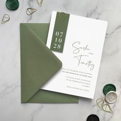 the wedding stationery is laid out on a marble table