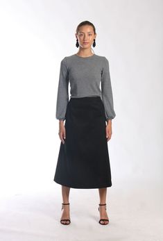 "Be right on clean minimal look with Aline midi skirt in timeless simplicity Black cotton skirt sits a little high on waist making your silhouette long and lean Midi length is super chic for this season Pair with simple top and heels or knee high boots to keep style minimal and polished Or wear as a chic casual skirt paired with snickers or athletic shoes -Tailored fit -Waist sits around naval -Side hidden zipper -Made of soft feel medium weighted cotton fabric with hint of stretch -Finishing is Fitted Wrap Skirt For Workwear, Classic Relaxed Fit Lined Maxi Skirt, Workwear Midi Skirt With Gathered Detail, Solid Full Maxi Skirt For Workwear, Workwear Gathered Pencil Skirt, Gathered Midi Skirt For Work, Fitted Flared Wrap Skirt For Fall, Relaxed Lined Skirt For Workwear, Full Maxi Skirt For Workwear