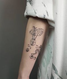 a person with a tattoo on their arm that has plants growing out of the ground