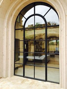 an arched window with glass panes on the outside