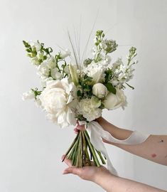 a person holding a bouquet of white flowers